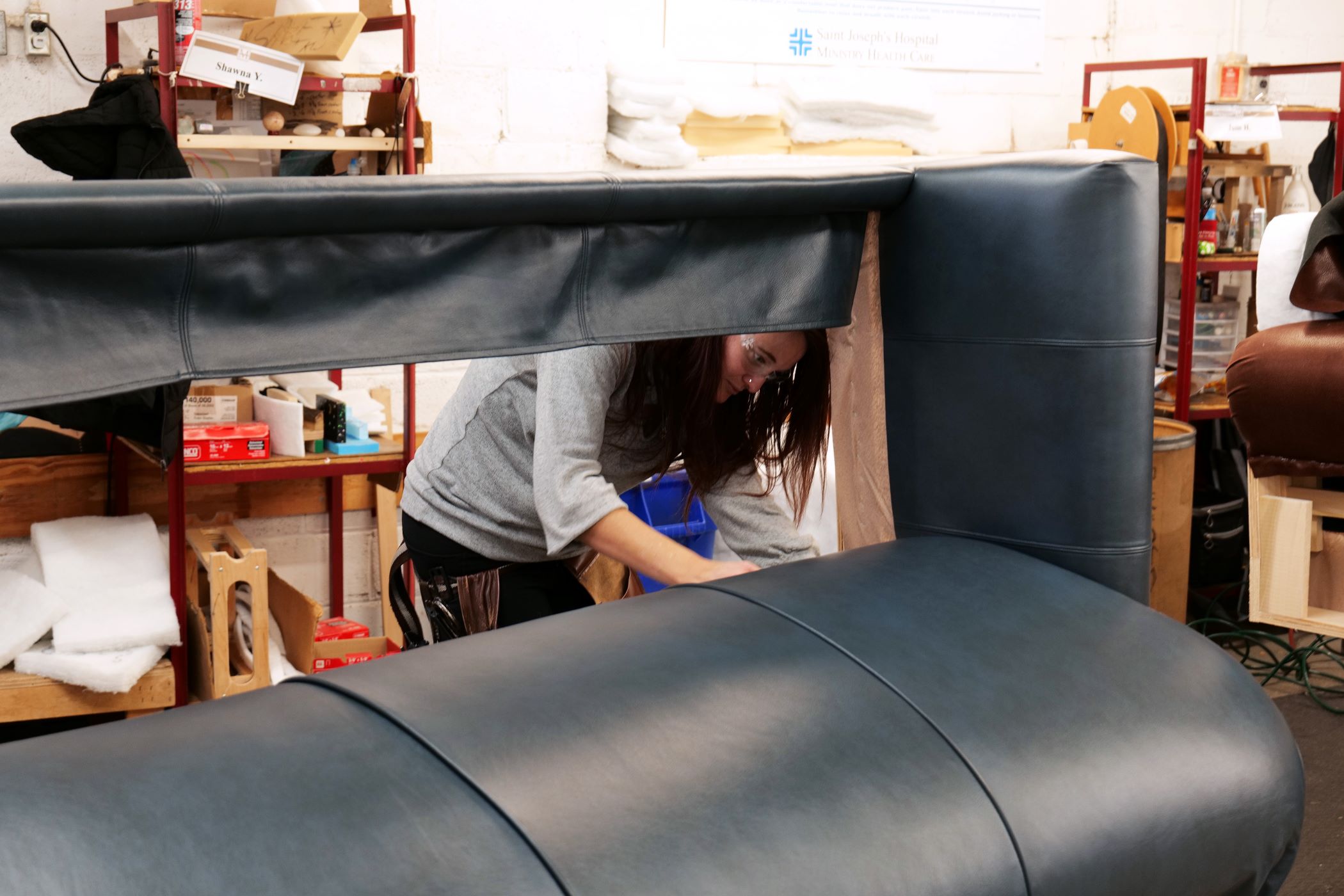 An upholstery Craftsmen from Marshfield Furniture works putting the leather covering on a sofa An upholstery Craftsmen from Marshfield Furniture works putting the leather covering on a sofa