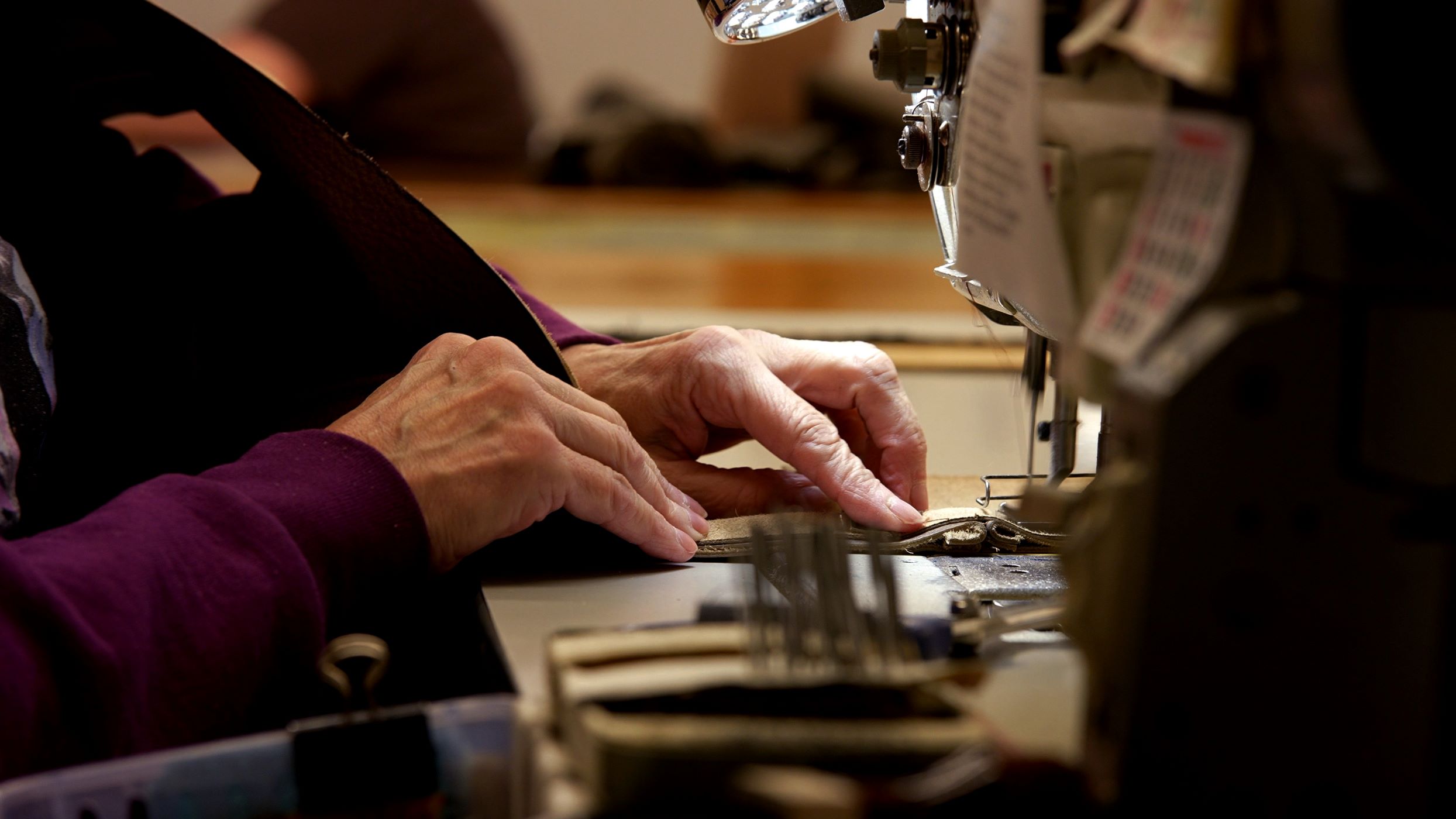 A seamstress from Marshfield Furniture Shop sews together upholstery for a piece of furniture A seamstress from Marshfield Furniture Shop sews together upholstery for a piece of furniture