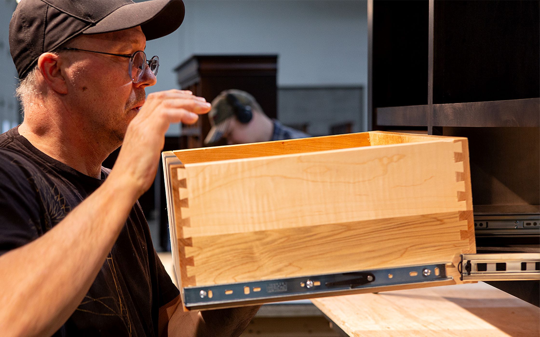A Craftsmen from the Mystic Creek Woodshop works on a sliding drawer for a piece of furniture A Craftsmen from the Mystic Creek Woodshop works on a sliding drawer for a piece of furniture