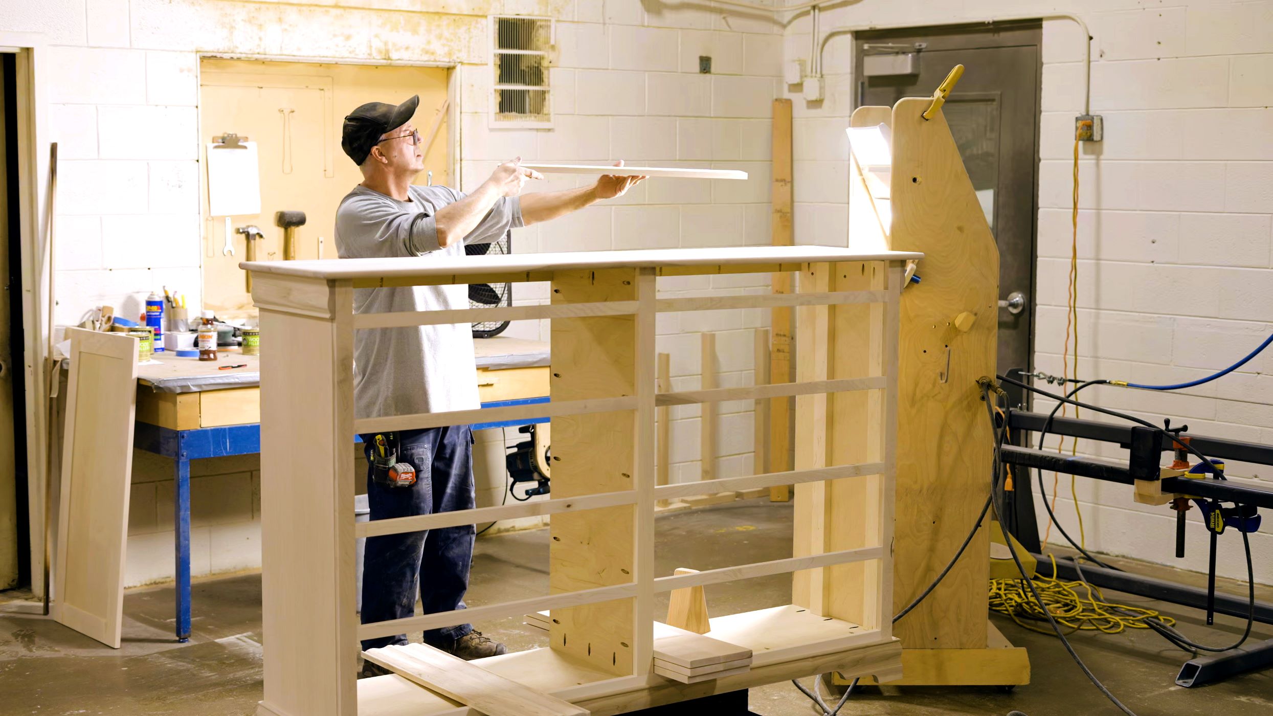 A Craftsmen from Mystic Creek Woodshop works on putting a chest of drawers together A Craftsmen from Mystic Creek Woodshop works on putting a chest of drawers together